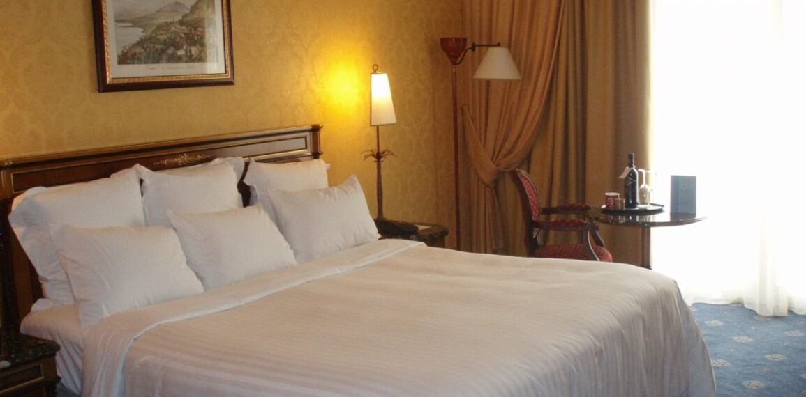 Perne albe pe patul unei camere de hotel